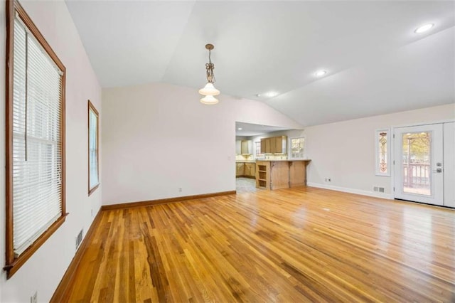 unfurnished living room with lofted ceiling and light wood-type flooring