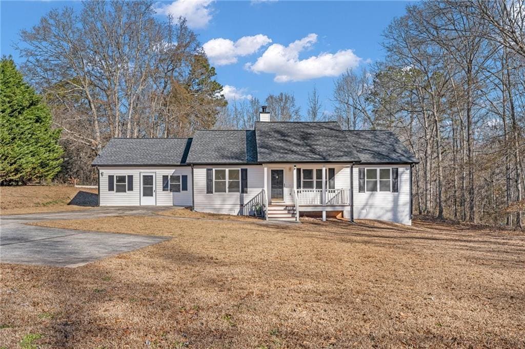 ranch-style home featuring a porch and a front lawn