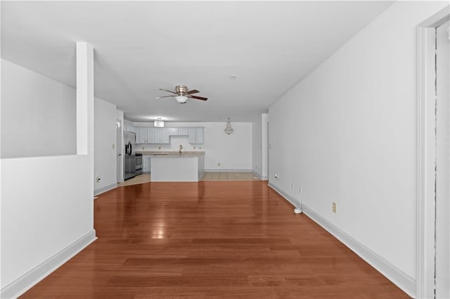 unfurnished living room featuring ceiling fan and wood-type flooring