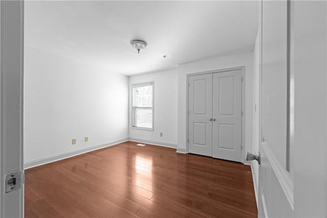 unfurnished bedroom with dark wood-type flooring