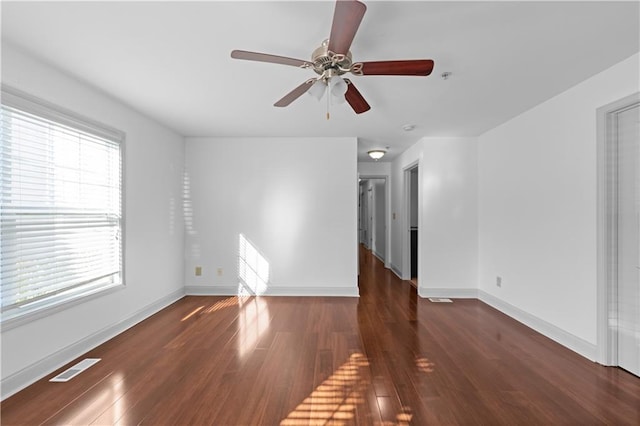 unfurnished living room featuring ceiling fan and dark wood-type flooring