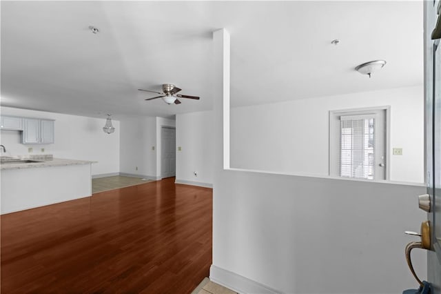 unfurnished living room with ceiling fan and wood-type flooring