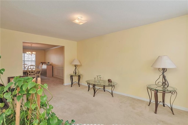living area featuring light carpet and an inviting chandelier