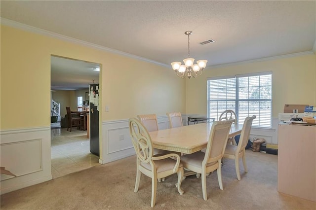 carpeted dining area featuring an inviting chandelier and ornamental molding