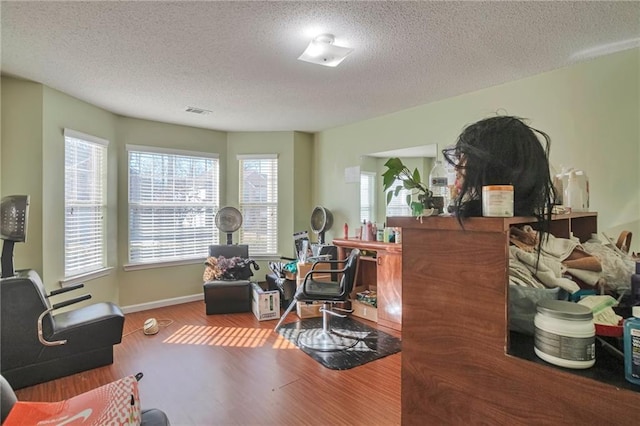living area featuring wood-type flooring and a textured ceiling