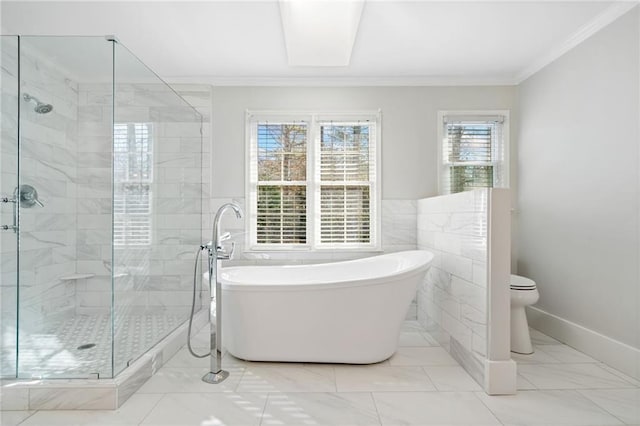 full bathroom with crown molding, tile walls, a freestanding bath, toilet, and a shower stall