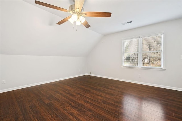 additional living space with lofted ceiling, dark wood-style flooring, visible vents, and baseboards