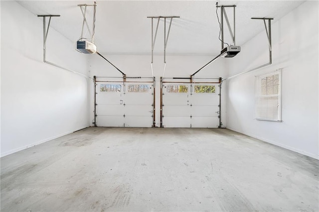 garage featuring a garage door opener and baseboards