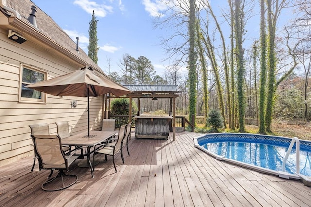 wooden deck with outdoor dining area and an outdoor pool