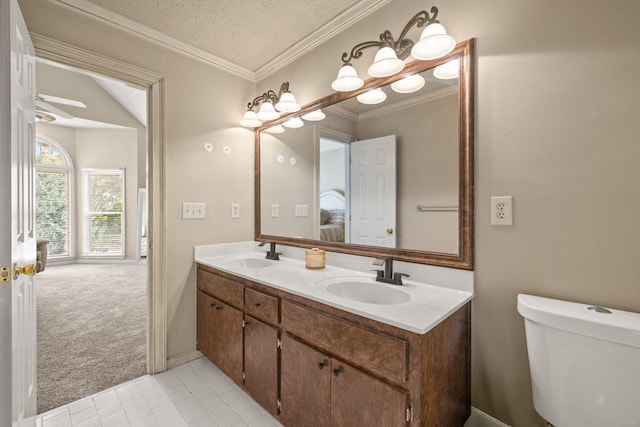 full bath featuring ornamental molding, a sink, toilet, and double vanity