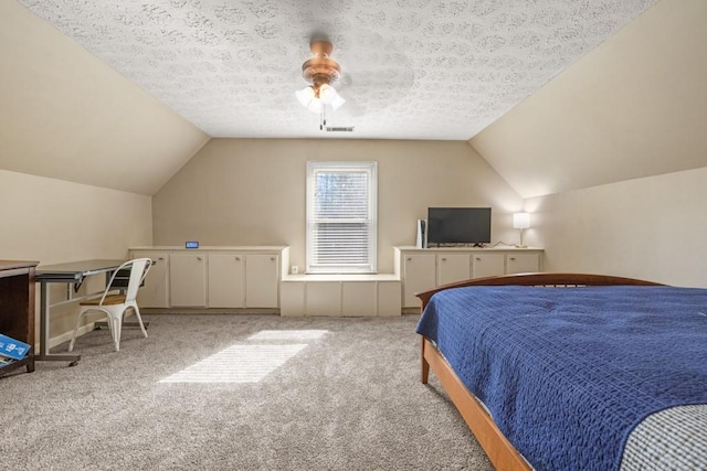 carpeted bedroom with vaulted ceiling, a textured ceiling, visible vents, and a ceiling fan