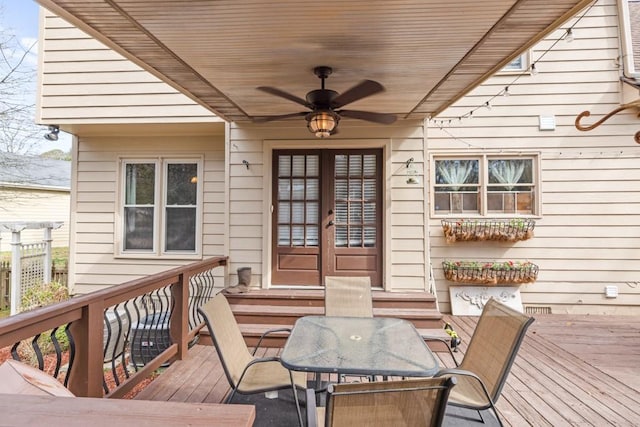 wooden terrace with entry steps, a ceiling fan, and outdoor dining space