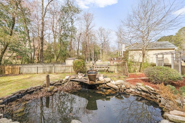 view of yard featuring fence private yard and a garden pond