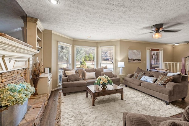 living area with a ceiling fan, crown molding, a textured ceiling, and wood finished floors