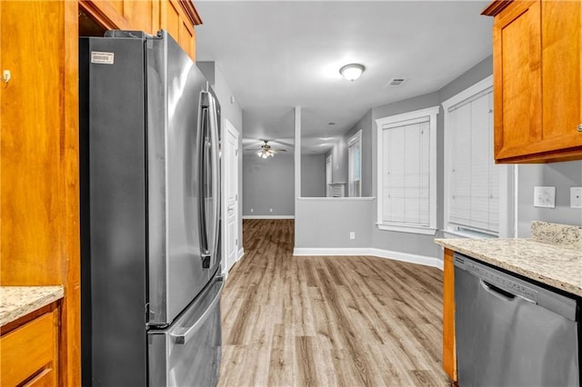 1714 Boulder Walk Ln SE, Atlanta, GA 30316 - kitchen with stainless steel appliances, light wood-style floors, baseboards, and brown cabinetry