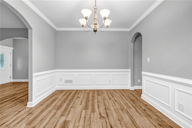 1714 Boulder Walk Ln SE, Atlanta, GA 30316 - unfurnished dining area featuring light wood-style floors, a chandelier, ornamental molding, arched walkways, and wainscoting