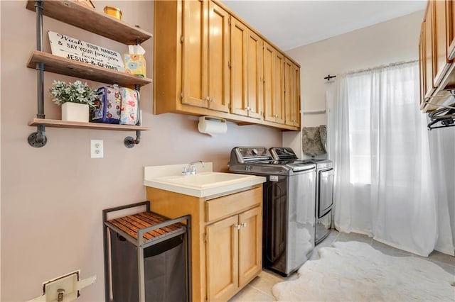 laundry room with cabinet space, washing machine and dryer, and a sink