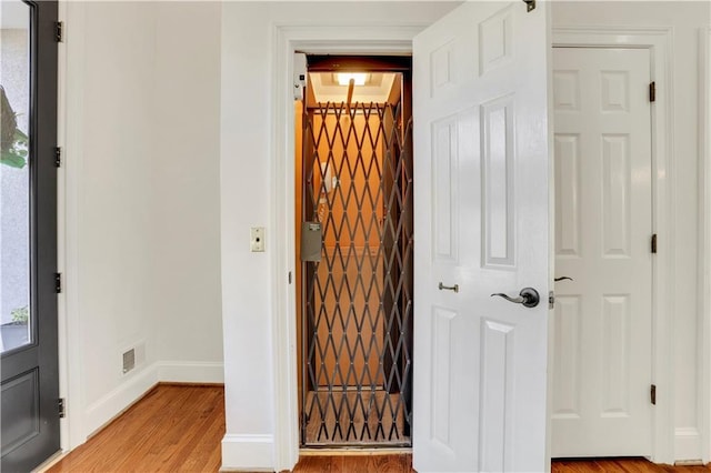 wine area with visible vents, light wood-style flooring, and baseboards