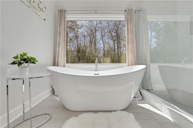 bathroom featuring a freestanding tub and tile patterned flooring