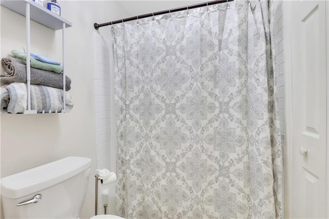 bathroom with curtained shower and toilet