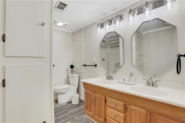 bathroom with a sink, visible vents, a shower with door, and double vanity