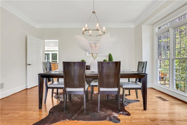 dining space featuring ornamental molding, wood finished floors, baseboards, and a chandelier