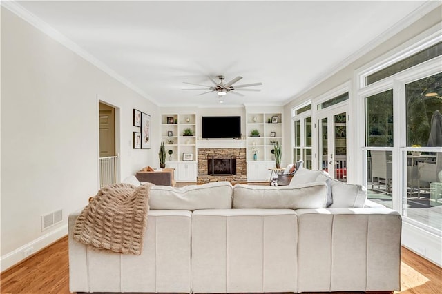 living room featuring visible vents, light wood finished floors, and ornamental molding