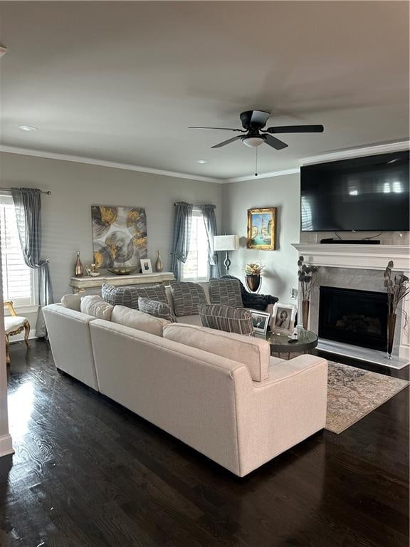 living room with dark hardwood / wood-style floors, plenty of natural light, ornamental molding, and a premium fireplace