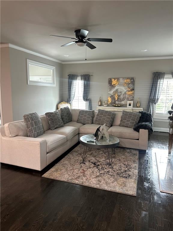 living room with crown molding, ceiling fan, and dark wood-type flooring