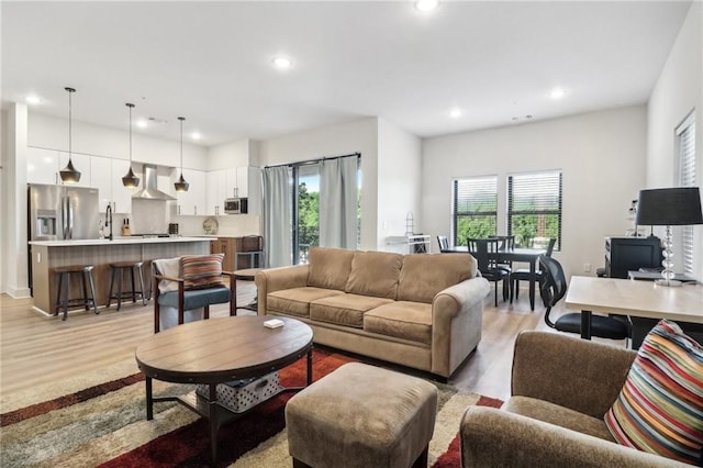 living room with a healthy amount of sunlight, recessed lighting, and light wood-style floors