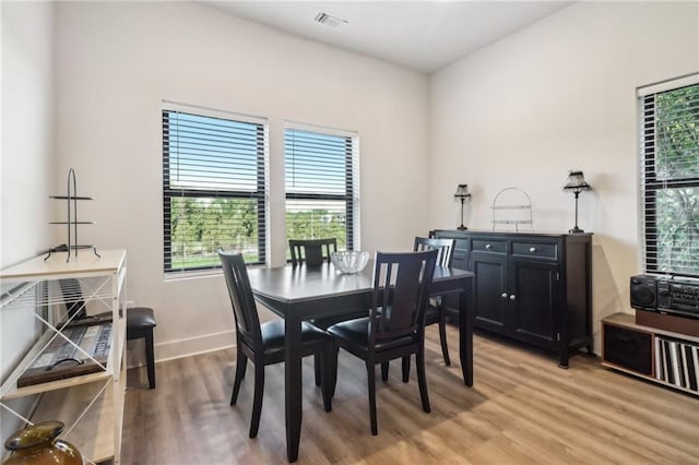 dining area featuring visible vents, light wood-style flooring, and baseboards