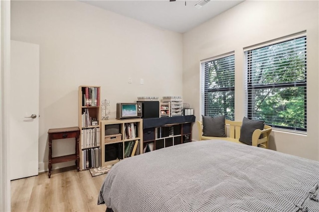 bedroom featuring multiple windows and wood finished floors