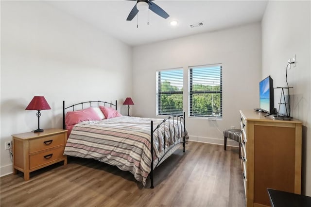 bedroom with a ceiling fan, light wood-type flooring, visible vents, and baseboards