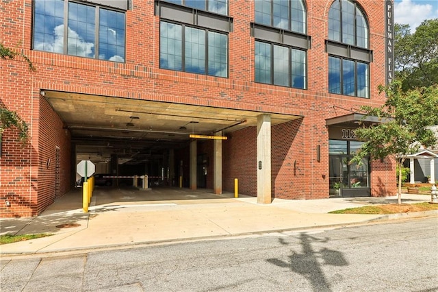 exterior space featuring concrete driveway and brick siding