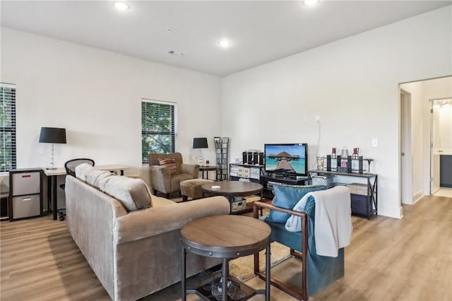 living area with light wood-type flooring, visible vents, and recessed lighting