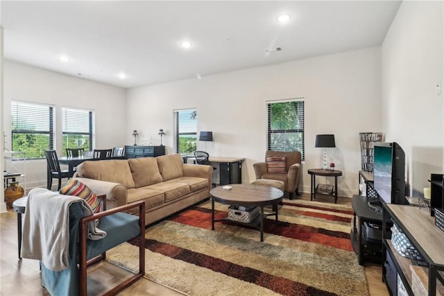 living room with baseboards, visible vents, and recessed lighting