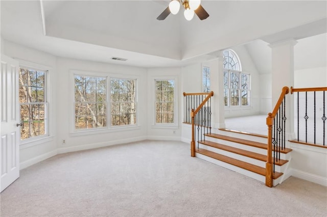 interior space with a tray ceiling, ceiling fan, and carpet