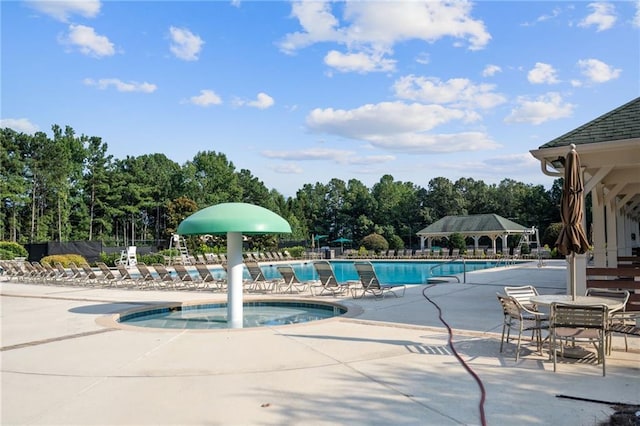 view of swimming pool featuring a jacuzzi and a patio area