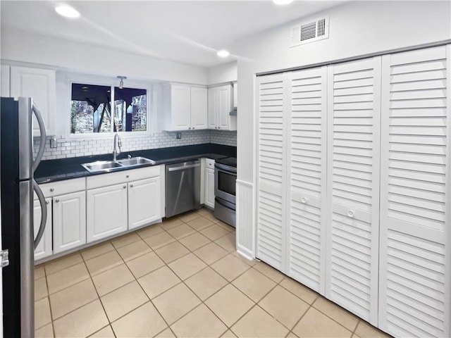 kitchen with appliances with stainless steel finishes, visible vents, a sink, and light tile patterned flooring