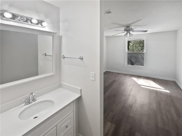 bathroom featuring wood finished floors, vanity, baseboards, visible vents, and a ceiling fan