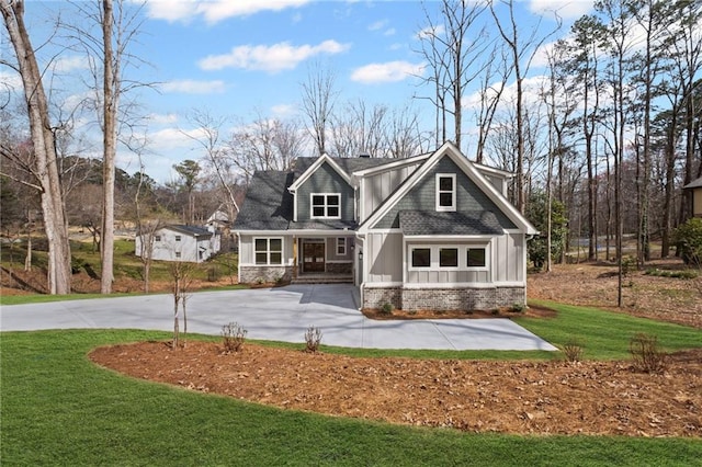 craftsman inspired home with curved driveway, board and batten siding, and a front lawn