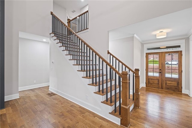 foyer featuring stairway, french doors, baseboards, and wood finished floors