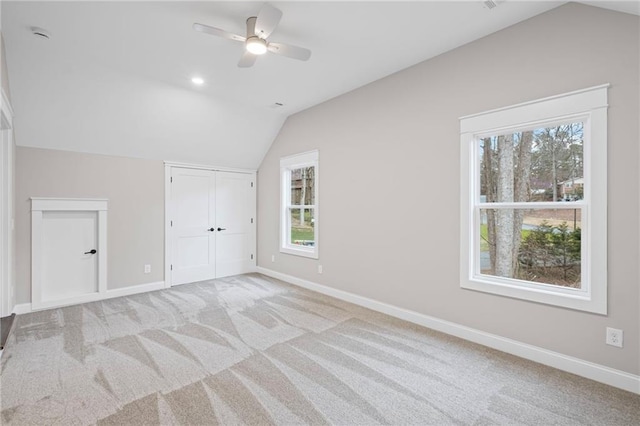 interior space with light carpet, baseboards, and lofted ceiling