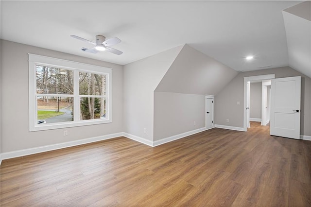 bonus room featuring vaulted ceiling, baseboards, and wood finished floors