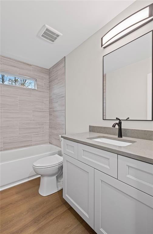 bathroom with visible vents, toilet, vanity, and wood finished floors