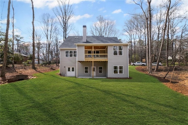 rear view of house with a patio area, a chimney, and a yard