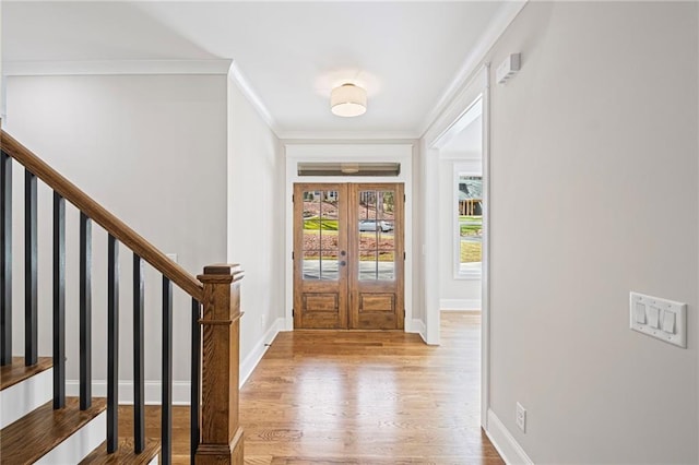 foyer entrance with baseboards, wood finished floors, and ornamental molding