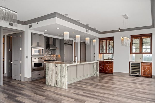 3630 Peachtree Rd NE Unit 2207, Atlanta, GA 30326 - kitchen featuring stainless steel appliances, wine cooler, wall chimney exhaust hood, wood finished floors, and decorative backsplash