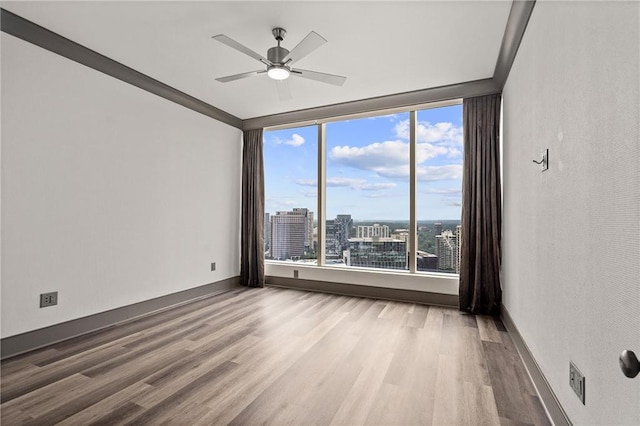 3630 Peachtree Rd NE Unit 2207, Atlanta, GA 30326 - unfurnished room featuring wood finished floors, a ceiling fan, a view of city, and baseboards