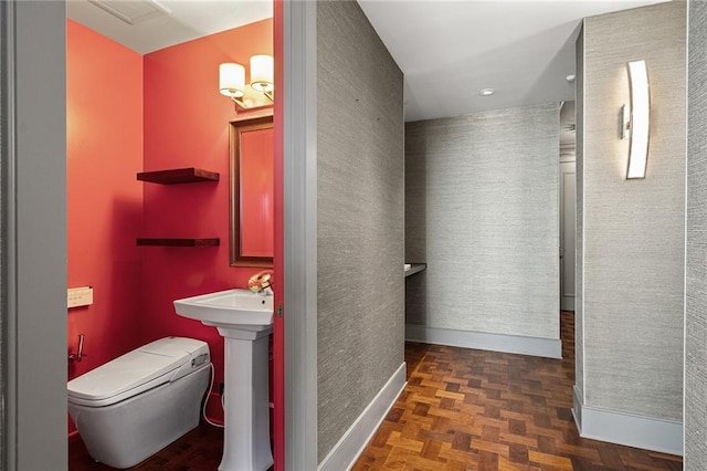 bathroom featuring toilet and parquet flooring